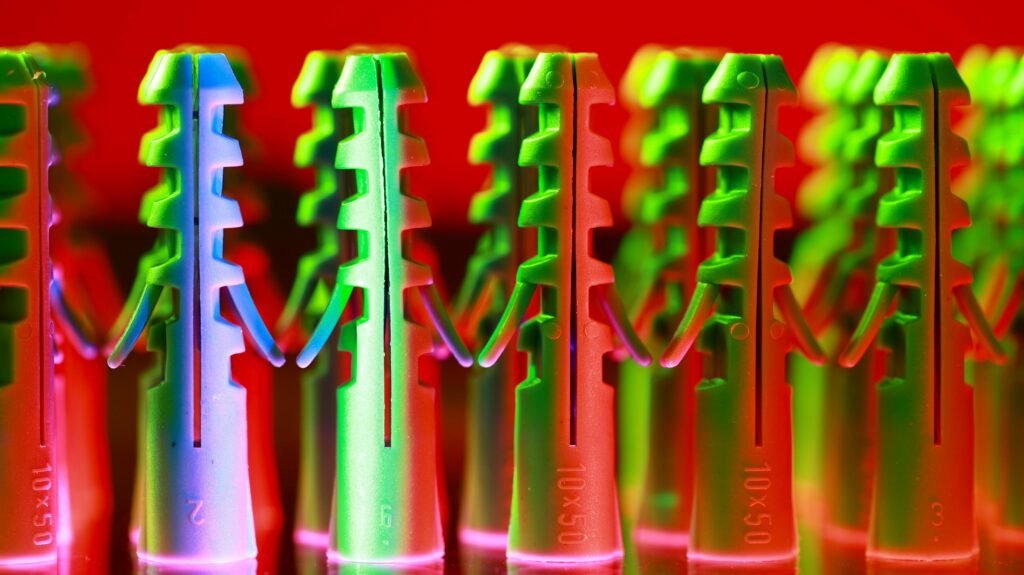 Vibrant close-up of colorful plastic wall anchors in abstract design.